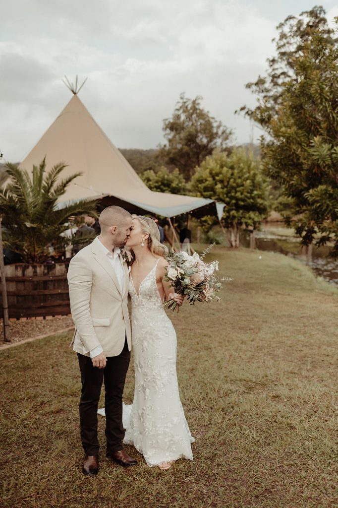 first kiss by the tipis, farm house wedding, teepee wedding